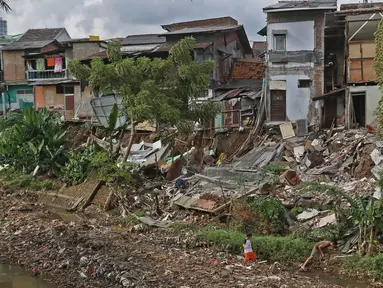 Anak-anak sedang bermain di bantaran kali Ciliwung kawasan Matraman Dalem, Jakarta, Selasa (3/3/2020). Rumah amblas akibat hujan lebat yang mengguyur Ibu kota. (Liputan6.com/Hermaan Zakharia)