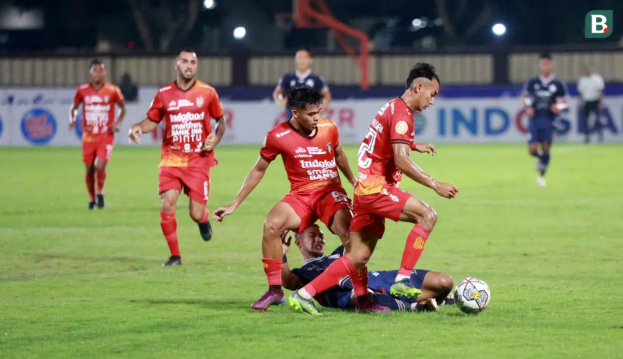 Pemain Bali United, Novri Setiawan dan Rahmat Reski, menghentikan pergerakan pemain Arema FC, Gian Zola, pada laga BRI Liga 1 di Stadion PTIK, Jakarta, Senin (27/3/2023). Arema menang dengan skor 3-1. (Bola.com/M Iqbal Ichsan)