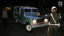 Petugas mengatur parkir mobil Land Rover klasik bak terbuka tumpangan Jokowi-Ma`ruf di gedung KPU Pusat, Jakarta, Jumat (21/9). Jokowi-Ma`ruf ke KPU untuk mengambil nomor urut Pilpres pasangan Capres dan Wapres 2019- 2024. (Liputan6.com/Fery Pradolo)