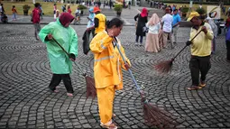 Petugas kebersihan membersihkan sisa sampah usai perayaan Tahun Baru 2019 di Monas, Jakarta, Selasa (1/1). Total sampah di DKI Jakarta saat perayaan Tahun Baru 2019 mencapai 327 ton. (Liputan6.com/Faizal Fanani)