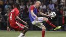 Gelandang Zinedine Zidane mengontrol bola dari kawalan Aldair saat pertandingan tim Prancis 98 dengan tim FIFA 98 di Arena U, Nanterre, Paris (12/6). Pertandingan ini memperingati 20 tahun kemenangan Prancis di Piala Dunia 1998. (AFP Photo/Thomas Samson)