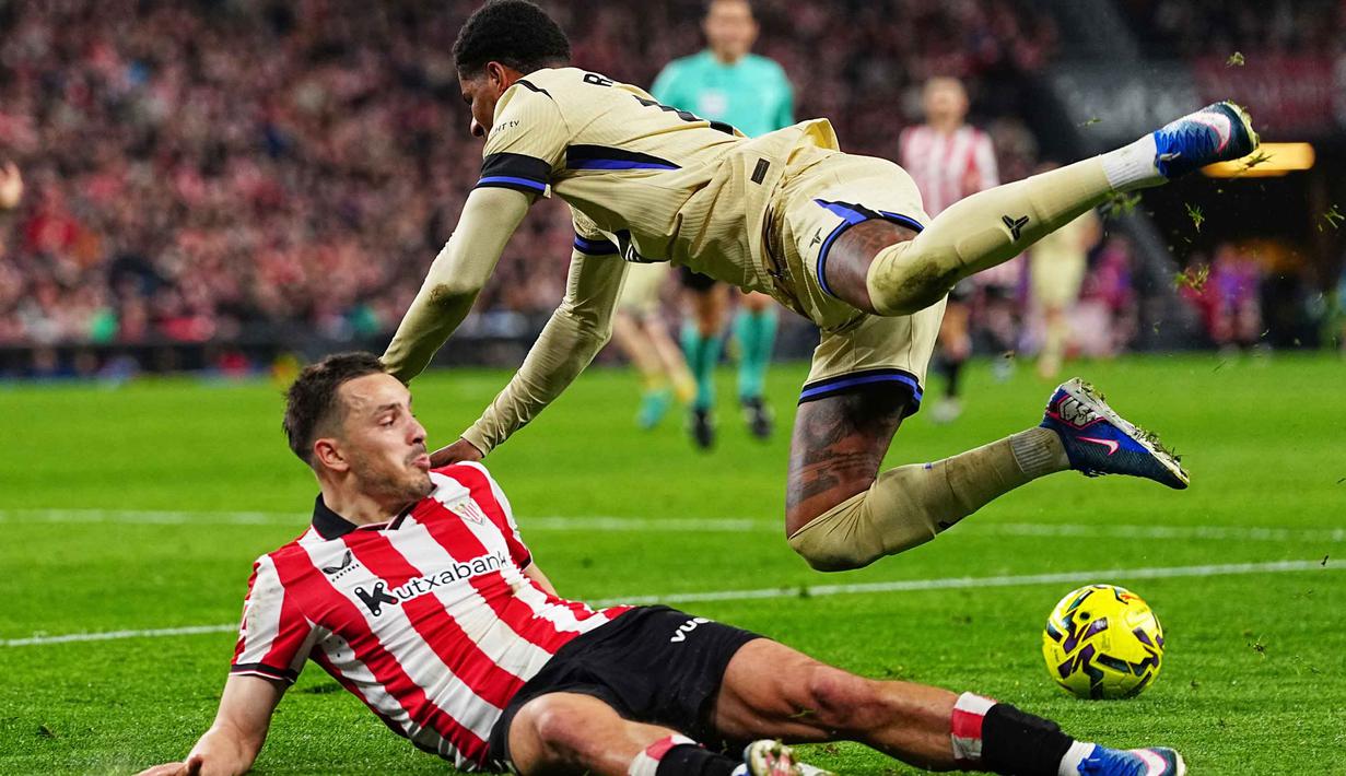 Berstatus sebagai tim tamu, Barcelona langsung mengontrol penguasaan bola sejak awal laga. Tampak dalam foto, pemain Barcelona, Marcus Rashford, melompati Andoni Gorosabel (bawah - Athletic Bilbao) pada pertandingan pekan ke-27 La Liga 2025/2026 di Stadion San Mames, Sabtu 7 Maret 2026 waktu setempat atau Minggu (8/3/2026) dini hari WIB. (AP Photo/Miguel Oses)