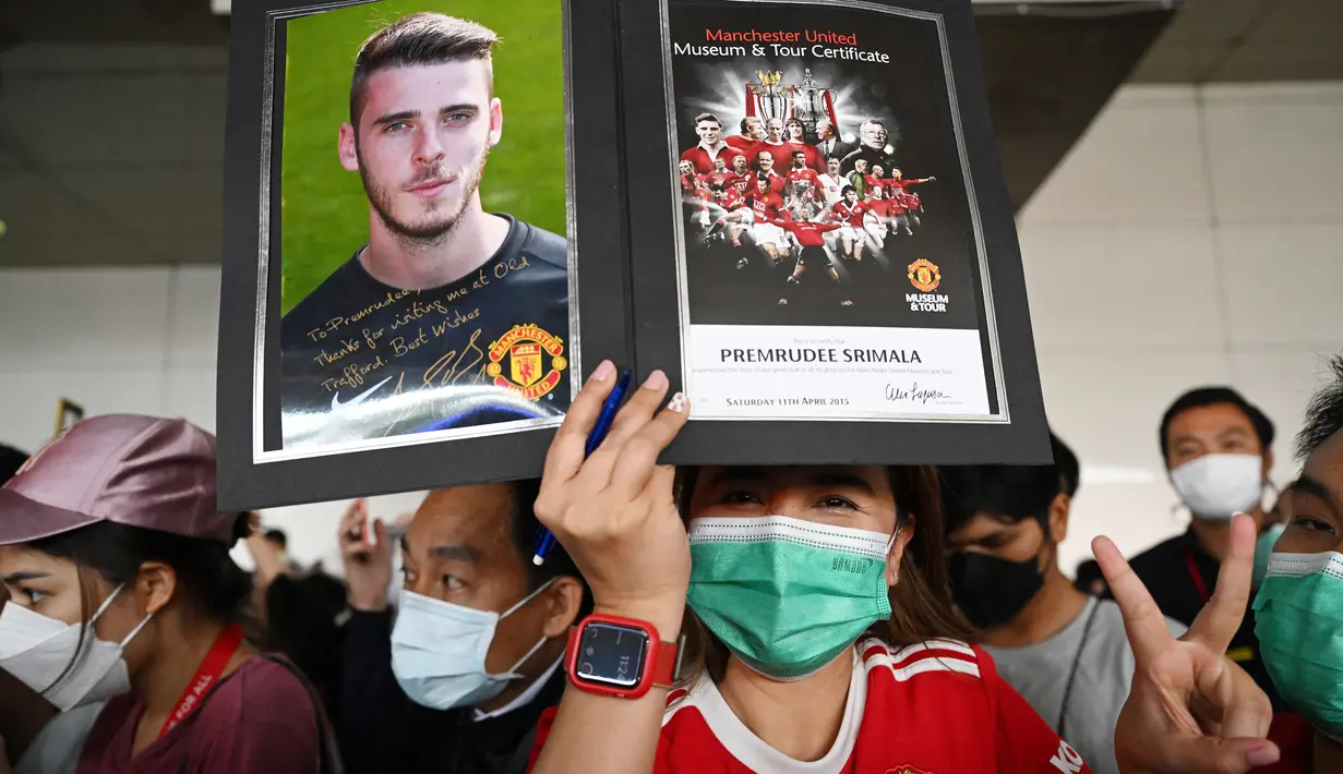 Penggemar Manchester United Football Club asal Thailand menyambut kedatangan skuad Setan Merah, Sabtu (9/7/2022) di bandara Bangkok, Thailand. (AFP/Manan Vatsyayana)