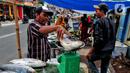 Pedagang menimbang ikan bandeng yang di jual di Rawa Belong, Jakarta, Jumat (20/1/2023). Penjual bandeng musiman ini menjual daganganya jelang perayaan Imlek yang dijual dengan harga mulai dari Rp. 50.000 hingga Rp. 90.000 per kilonya. (Liputan6.com/Angga Yuniar)