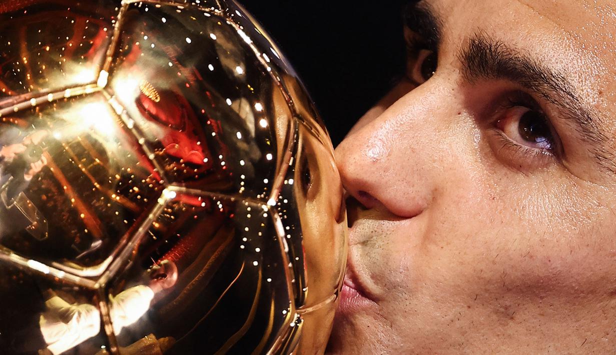 Pemain Manchester City, Rodri mencium trofi Ballon d'Or 2024 pada acara penghargaan yang berlangsung di Theatre du Chatelet, Paris, Selasa (29/10/2024) dini hari WIB. (AFP/Franck Fife)