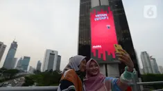 Warga berselfie di kawasan jalan Jenderal Sudirman, Jakarta,Sabtu (18/7/2020). Pemerintah Provinsi DKI Jakarta memperpanjang PSBB fase transisi selama 14 hari hingga 30 Juli, seiring kasus baru COVID-19 masih tinggi di ibu kota. (merdeka.com/Imam Buhori)