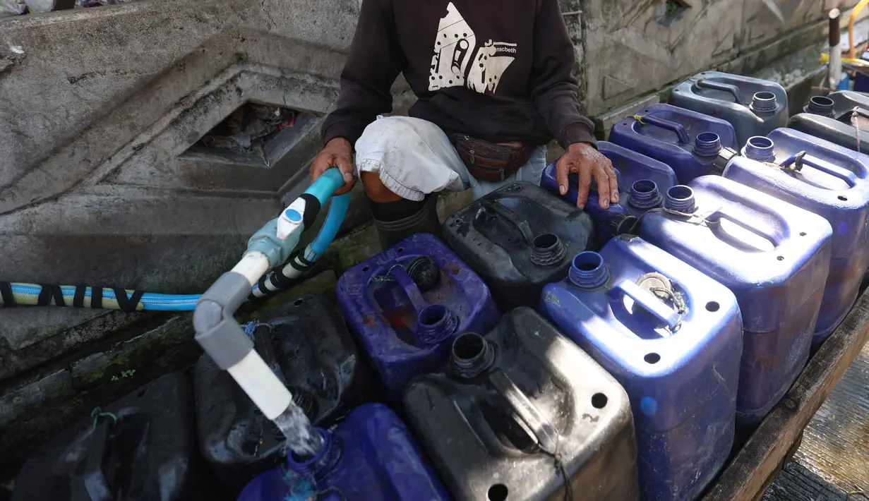 Pedagang mengisi jeriken dengan air bersih untuk segera didistribusikan kepada pelanggan di Kawasan Muara Angke, Jakarta, Kamis (28/5/2026). (Kapanlagi.com/Budy Santoso)