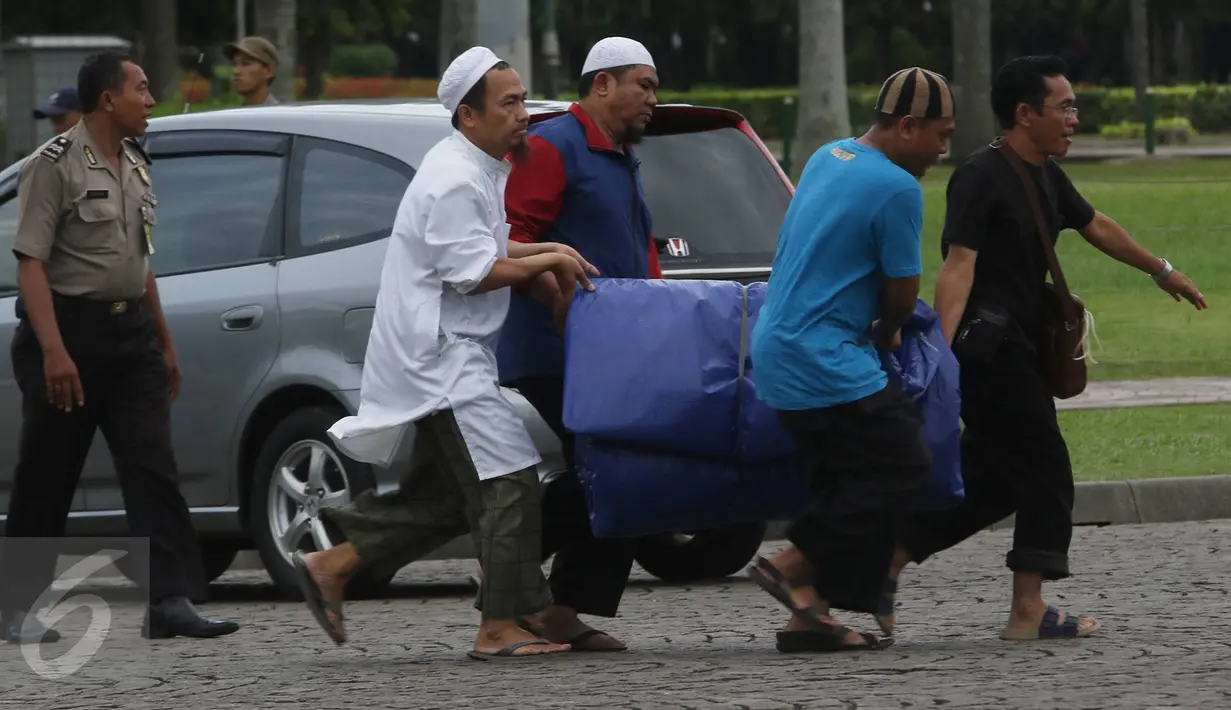 Warga mempersiapkan kelengkapan aksi damai 2 Desember di Monas, Jakarta, Kamis (1/12). Jelang aksi damai, sejumlah persiapan mulai dilakukan, seperti panggung, baris untuk Salat Jumat, hingga pengamanan dari kepolisian. (Liputan6.com/Immanuel Antonius)