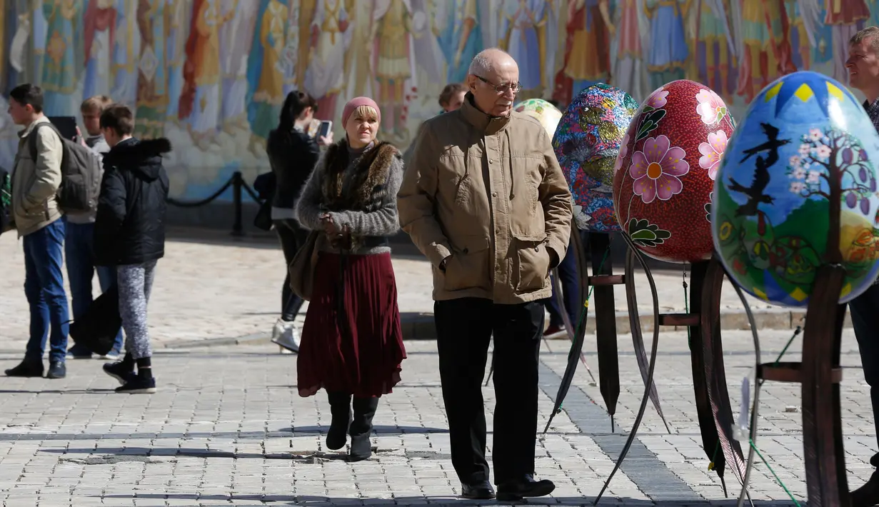 Pengunjung melihat telur Paskah yang dipajang di depan Katedral Mikhaylivsky di pusat Kiev sebelum perayaan Paskah, Ukraina, Rabu (12/4). Pameran telur Paskah ini biasa digelar menjelang perayaan Paskah. (AP Photo / Sergei Chuzavkov)