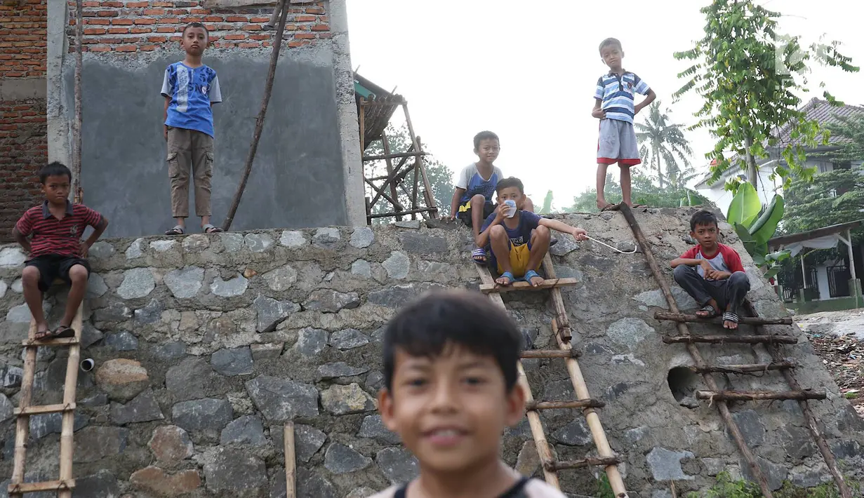 Anak-anak bermain di RPTRA Pelangi Cipedak yang pembangunannya terhenti di Jakarta, Senin (18/3). Terhentinya pembangunan RPTRA yang telah tiga kali mangkrak dikeluhkan warga karena molor dari target yang ditentukan. (Liputan6.com/Immanuel Antonius)