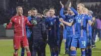 Para pemain Islandia merayakan keberhasilan lolos ke Piala Dunia 2018 usai mengalahkan Kosovo di Reykjavik, Senin (9/10/2017). Islandia untuk pertama kali dalam sejarah lolos ke Piala Dunia. (AFP/Haraldur Gudjonsson)