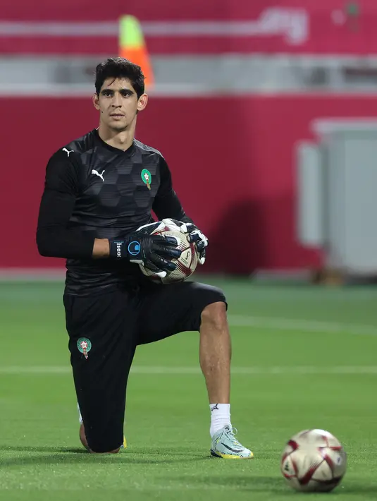 <p>Kiper Maroko, Yassine Bounou memegang bola saat mengikuti sesi latihan tim di Stadion Al Duhail SC di Doha (16/12/2022). Maroko akan bertanding melawan Kroasia untuk memperebutkan juara 3 Piala Dunia 2022. Keduanya dipertemukan kembali setelah pernah bertanding pada babak penyisihan grup F lalu. (AFP/Karim Jafaar)</p>