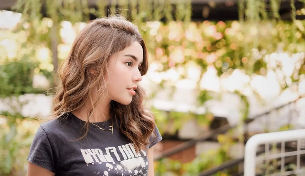 Fay Nabila tampak dewasa saat menggunakan baju kaus band asal Inggris Pink Floyd berwarna hitam. Rambutnya yang kecoklatan, bersinar diterpa sinar matahari, membuatnya terlihat semakin menawan. (Liputan6.com/IG/@faynabilalxndr)
