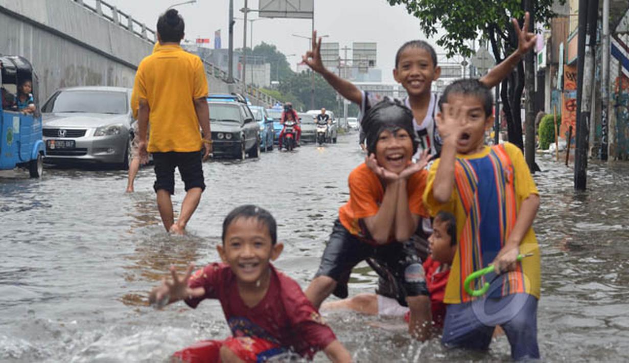Sejumlah anak-anak bermain di lokasi banjir kawasan Jalan Pramuka, Jakarta, Minggu (1/2/2015). (Liputan6.com/Andrian M Tunay) 