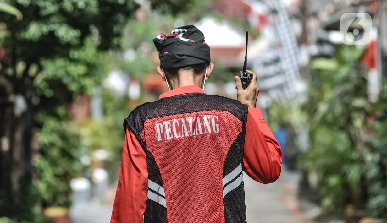 Puryanto (50) yang bertugas sebagai pecalang menjaga perayaan Hari Raya Nyepi di Kampung Bali, Harapan Jaya, Bekasi, Jawa Barat, Minggu (14/3/2021). Jarang warga yang beraktivitas di luar rumah selama perayaan Hari Nyepi berlangsung. (merdeka.com/Iqbal S. Nugroho)