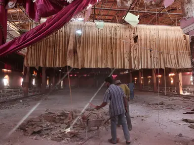 Warga membersihkan puing-puing bangunan usai serangan bom bunuh diri yang meneror sebuah pesta pernikahan di Hasaka, Suriah, Selasa (4/10). Diduga serangan bom tersebut didalangi ISIS.(REUTERS/Rodi Said)