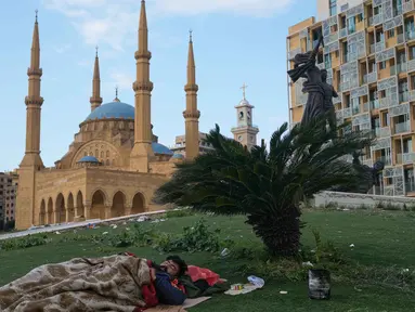 Seorang pria yang melarikan diri dari serangan udara Israel di Dahiyeh, pinggiran selatan Beirut, beristirahat di Lapangan Martir di pusat kota Beirut, Lebanon, Sabtu 7 Maret 2026. Untuk menghindari serangan udara Israel yang menyasar kawasan permukiman, terutama di wilayah Dahiyeh, ratusan warga Beirut, Lebanon, memilih tidur di trotoar, taman, mobil, dan tepi laut. (AP Photo/Bilal Hussein)