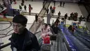 Penumpang menggunakan eskalator di stasiun kereta api Beijing, Selasa (29/1). Jutaan orang China telah memulai migrasi manusia terbesar di dunia meninggalkan kota-kota besar menuju kampung halaman untuk merayakan Tahun Baru Imlek. (Nicolas ASFOURI/AFP)