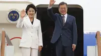 Ibu negara Korea Selatan Kim Jung-sook bersama Presiden Moon Jae-in melambaikan tangan dari atas pesawat kepresidenan (AP/Hwang Kwang Mo)