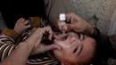 Seorang anak dipegangi orang tuanya saat petugas memberikan imunisasi polio di sepanjang jalan di Quetta, Pakistan, Senin (2/1). (REUTERS/Naseer Ahmed)