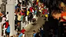 Seekor banteng berlari mengejar para peserta yang menghindar dan menaiki jendela di jalanan kota saat festival Toro de Cuerda di Grazalema, Spanyol, (20/7/2015). Tiga banteng dilepas di jalanan kota dalam festival tahunan tersebut. (REUTERS/Jon Nazca)