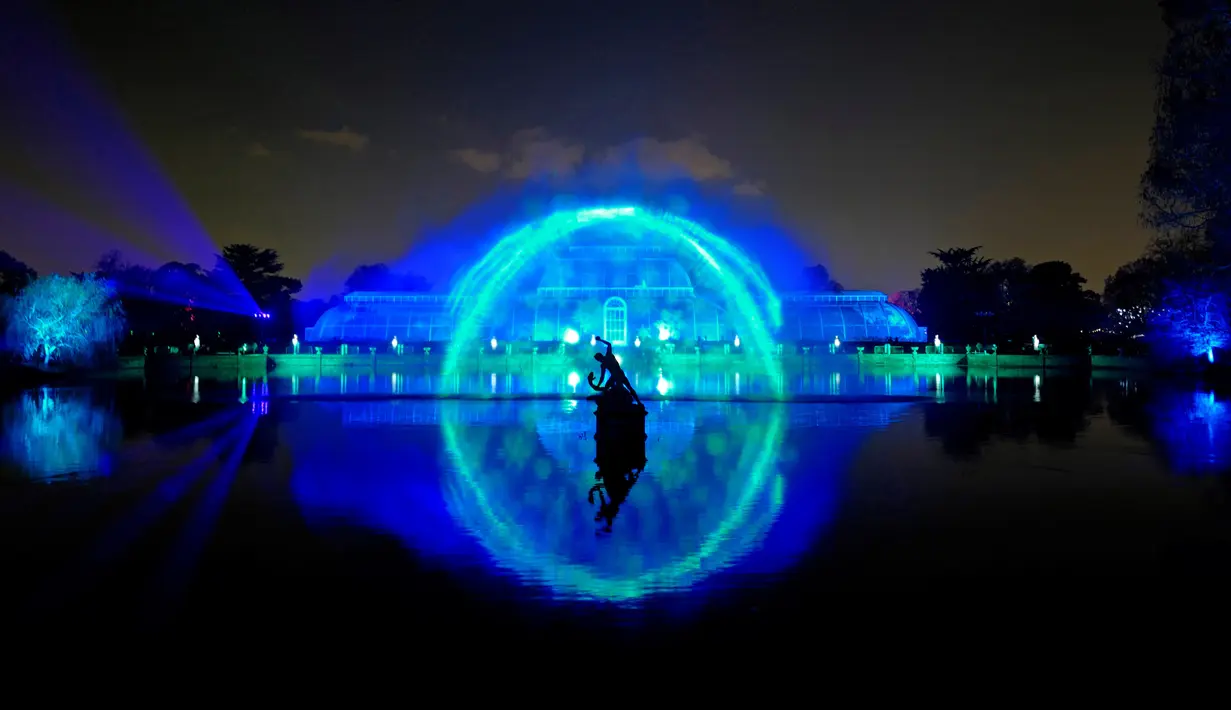 Proyeksi gambar dari sinar laser  pada lapisan air yang disemprotkan ke udara di depan Palm House, Kew Gardens di London, 21 November 2018. Momen langka ini mulai dibuka untuk publik dimulai pada 22 November 2018 hingga 5 Januari 2019. (Tolga AKMEN/AFP)
