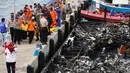 Petugas kepolisian bersama Tim SAR gabungan mengevakuasi kantong jenazah korban kapal Zahro Express yang terbakar, di Pelabuhan Muara Angke, Minggu (1/1). Sejumlah jenazah ditemukan dengan kondisi hangus terbakar dari kapal. (REUTERS/Darren Whiteside)