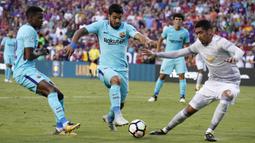 Striker Barcelona, Luis Suarez, berusaha melewati bek Manchester United, Chris Smailing, pada laga ICC di Stadion FedEx Field, Maryland, Rabu (26/7/2017). Barcelona menang 1-0 atas Manchester United. (EPA/Shawn Thew)