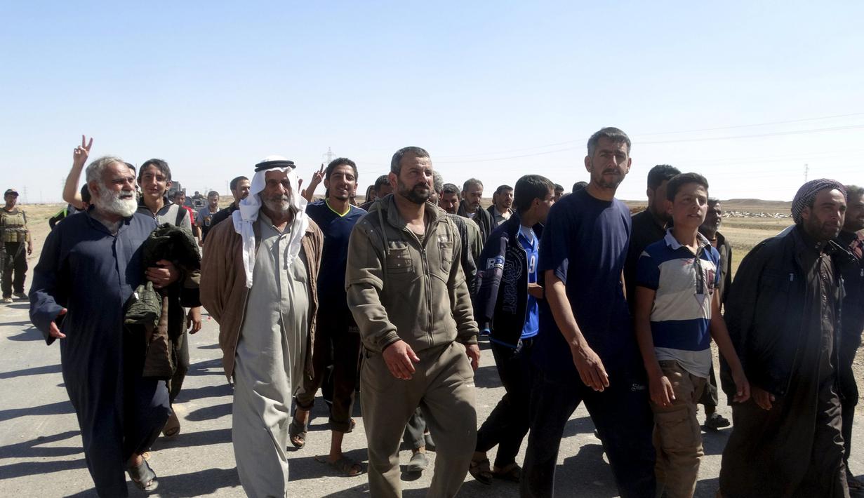 Puluhan warga berjalan saat melarikan diri setelah terjadi pertempuran antara pasukan Irak dan militas ISIS di kota Hit, provinsi Anbar, (5/4/2016). (REUTERS/Stringer)