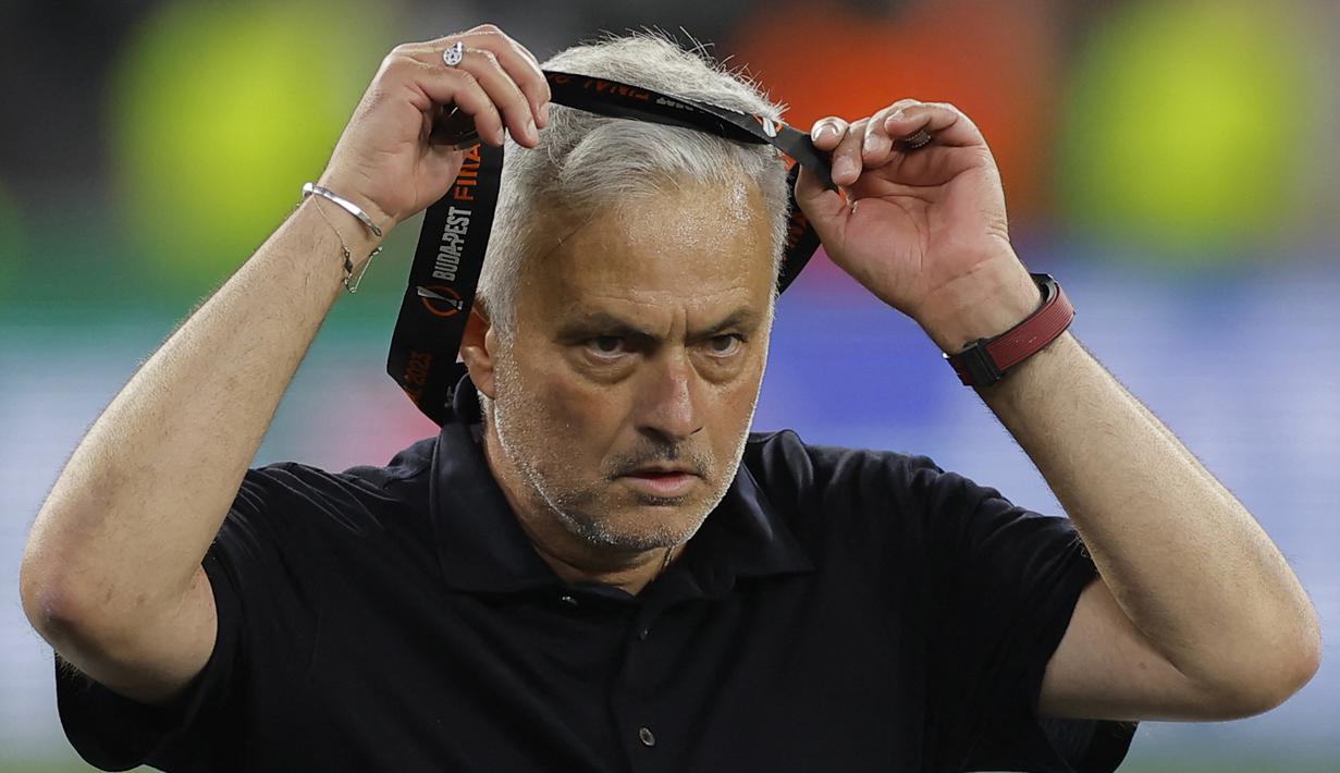 Pelatih AS Roma, Jose Mourinho melepaskan medali dari tubuhnya setelah timnya dikalahkan Sevilla lewat babak adu penalti dalam partai final Liga Europa 2022/2023 yang berlangsung di Stadion Puskas Arena, Hungaria, Jumat (01/06/2023) dini hari WIB. (AFP/Odd Andersen)