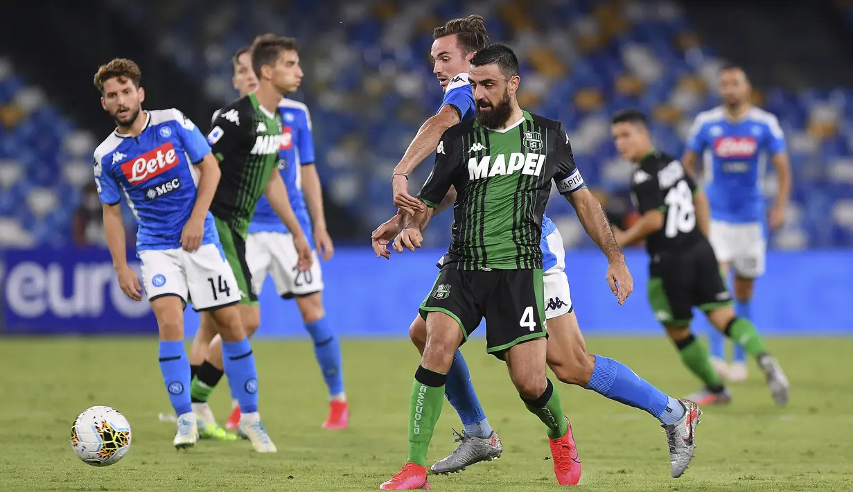 Pemain Napoli Fabian Ruiz dan pemain Sassuolo Francesco Manganelli (tengah) berebut bola pada pertandingan Serie A di Stadion San Paolo, Naples, Italia, Sabtu (25/7/2020). Napoli mengalahkan Sassuolo dengan skor 2-0. (Cafaro/LaPresse via AP)