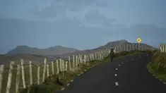 Seorang wanita berjalan menyusuri jalan di Coumeenoole, Irlandia, Selasa (27/12). Irlandia mendapat julukan Pulau Zamrud karena memiliki pemandangan alam yang hijau terang. (REUTERS / Clodagh Kilcoyne)