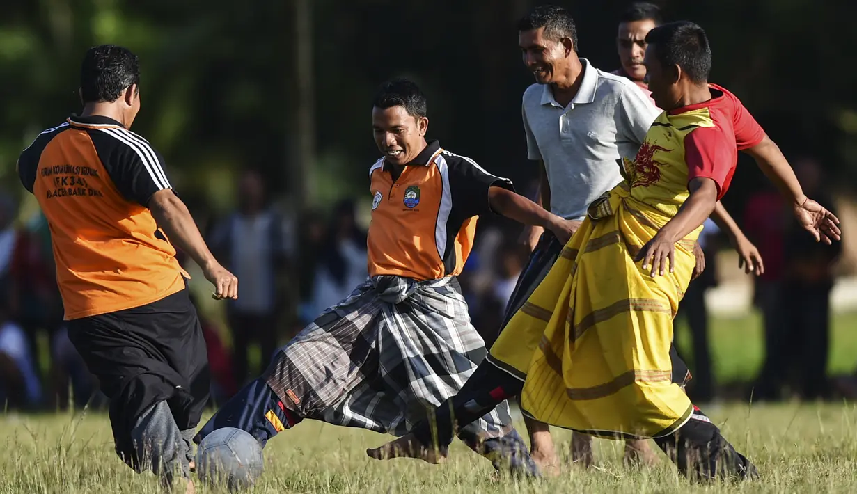 Penduduk desa bermain sepak bola dengan mengenakan sarung saat merayakan HUT ke-74 RI di Blang Pidie provinsi Aceh (17/8/2019). Indonesia merayakan kemerdekaan yang ke-74 dari pemerintahan kolonial Belanda. (AFP Photo/Chaideer Mahyuddin)