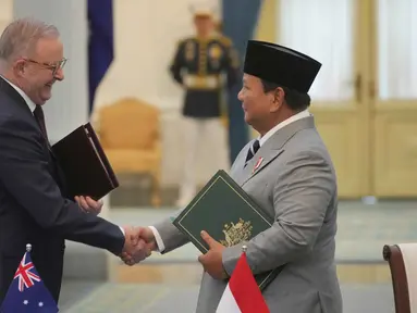 Presiden Republik Indonesia, Prabowo Subianto (kanan) dan Perdana Menteri Australia. Anthony Albanese, bertukar dokumen yang baru saja mereka tandatangani selama pertemuan di Istana Merdeka, Jakarta, Jumat 6 Februari 2026. (AP Photo/Achmad Ibrahim)