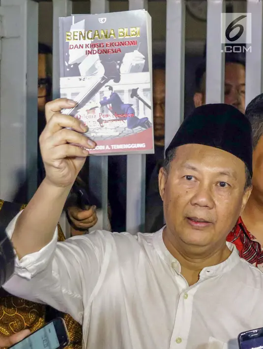 Mantan Kepala BPPN, Syafruddin Arsyad Temenggung menunjukkan buku yang ditulisnya saat meninggalkan rumah tahanan KPK, Jakarta, Selasa (7/9/2019). Sebelumnya, ditingkat banding Pengadilan Tinggi DKI Jakarta memperberat hukuman Syafruddin Arsyad Temenggung. (Liputan6.com/Helmi Fithriansyah)