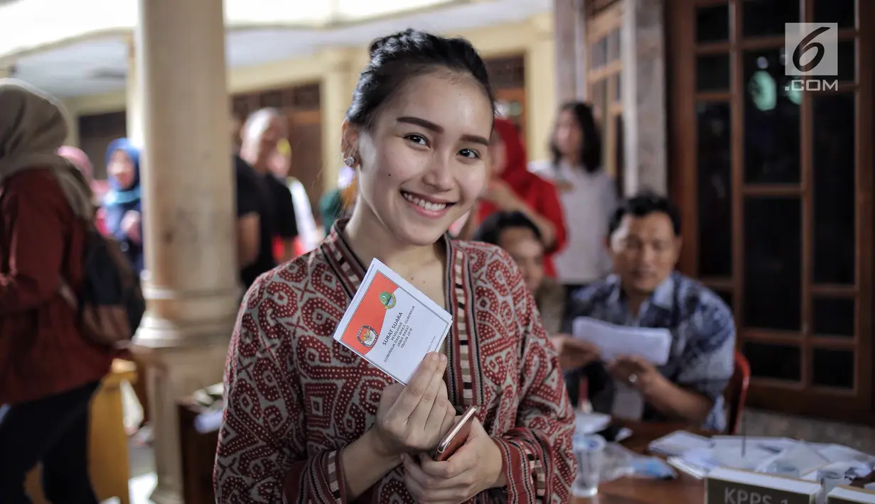 Penyanyi dangdut Ayu Ting Ting berpose memegang surat suara sbeelum mencoblos pada Pilkada Serentak 2018 di  TPS 5, Sukma Jaya, Depok, Rabu (27/6). Kota Depok bersiap menentukan gubernur Jawa Barat untuk 5 tahun mendatang. (Liputan6.com/Faizal Fanani)