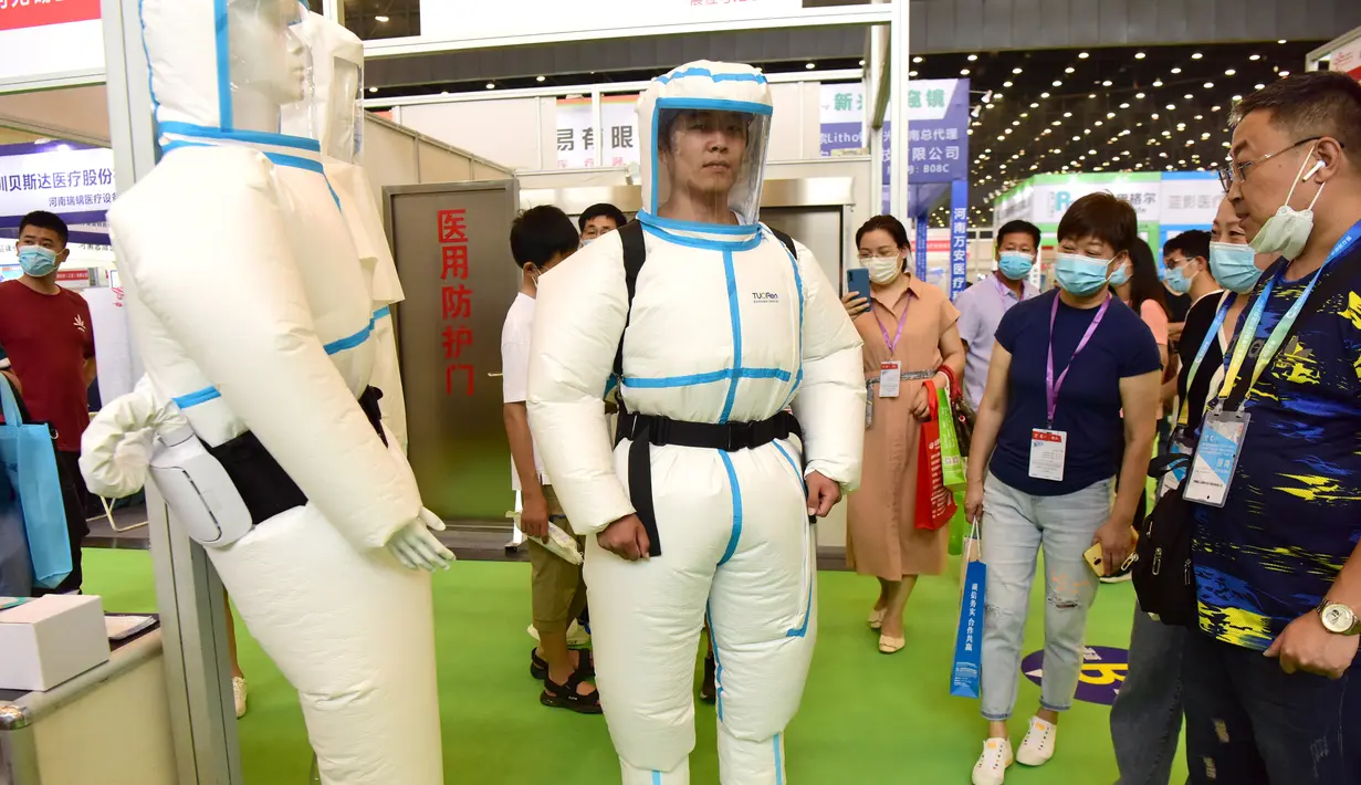 Seorang pengunjung menjajal pakaian pelindung di pameran peralatan medis di Zhengzhou, Provinsi Henan, China tengah (4/8/2020). Pameran yang berlangsung selama tiga hari itu digelar di Zhengzhou pada Selasa (4/8) dan diikuti oleh lebih dari 1.000 peserta dari seantero China. (Xinhua/Zhu Xiang)