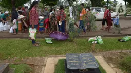 Antrean warga saat pembagian beras, minyak goreng dan nasi kotak di TPU Malaka, Pondok Kopi, Jakarta, Jumat (4/3/2022). Pembagian sejumlah sembako secara gratis yang diperuntukan bagi kaum duafa ini berupa beras dan minyak goreng. (merdeka.com/Imam Buhori)