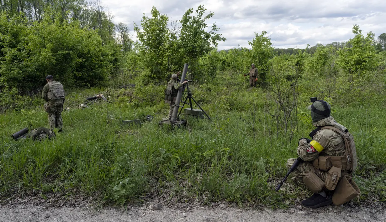 Prajurit Ukraina didampingi anggota legiun asing menembakkan mortir ke posisi Rusia di wilayah Kharkiv, Ukraina, 17 Mei 2022. (AP Photo/Bernat Armangue)