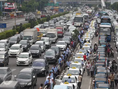 Kemacetan parah terjadi di sepanjang tol dalam kota dan Jalan Gatot Subroto, Jakarta, Selasa (22/3). Ribuan sopir taksi memblokir jalan protokol tersebut hingga membuat kendaraan lain tidak bisa lewat. (Liputan6.com/Immanuel Antonius)