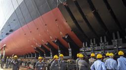 Para pekerja bersiap untuk upacara peluncuran kapal perang INS Udaygiri di halaman Mazagaon Dock Shipbuilders Limited, Mumbai, India, Selasa (17/5/2022). (Punit PARANJPE/AFP)