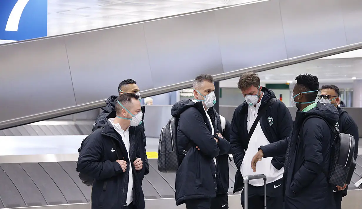 Para pemain Ludogorets mengenakan masker saat tiba di bandara Malpensa di Milan, Italia (26/2/2020). Mengantisipasi menularnya COVID-19, pertandingan antara Inter Milan dan Ludogorets  tanpa penonton. (Ludogorets FC via AP)