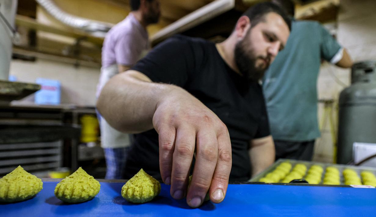 Jika orang Indonesia identik dengan sajian kue nastar, maka berbeda dengan halnya warga di negara seperti Palestina. (Photo by AHMAD GHARABLI / AFP)
