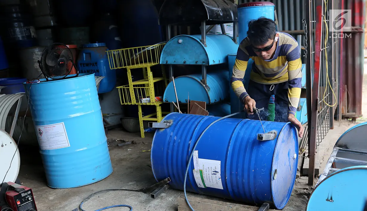 Pekerja sedang mengelas drum bekas untuk bahan membuat kursi di industri kecil Ali Kreatif, Parung Bogor, Selasa (30/1). Industri yang beromset 20 juta rupiah setiap minggunya juga memproduksi tempat sampah, lemari hingga meja. (Liputan6.com/Fery Pradolo)