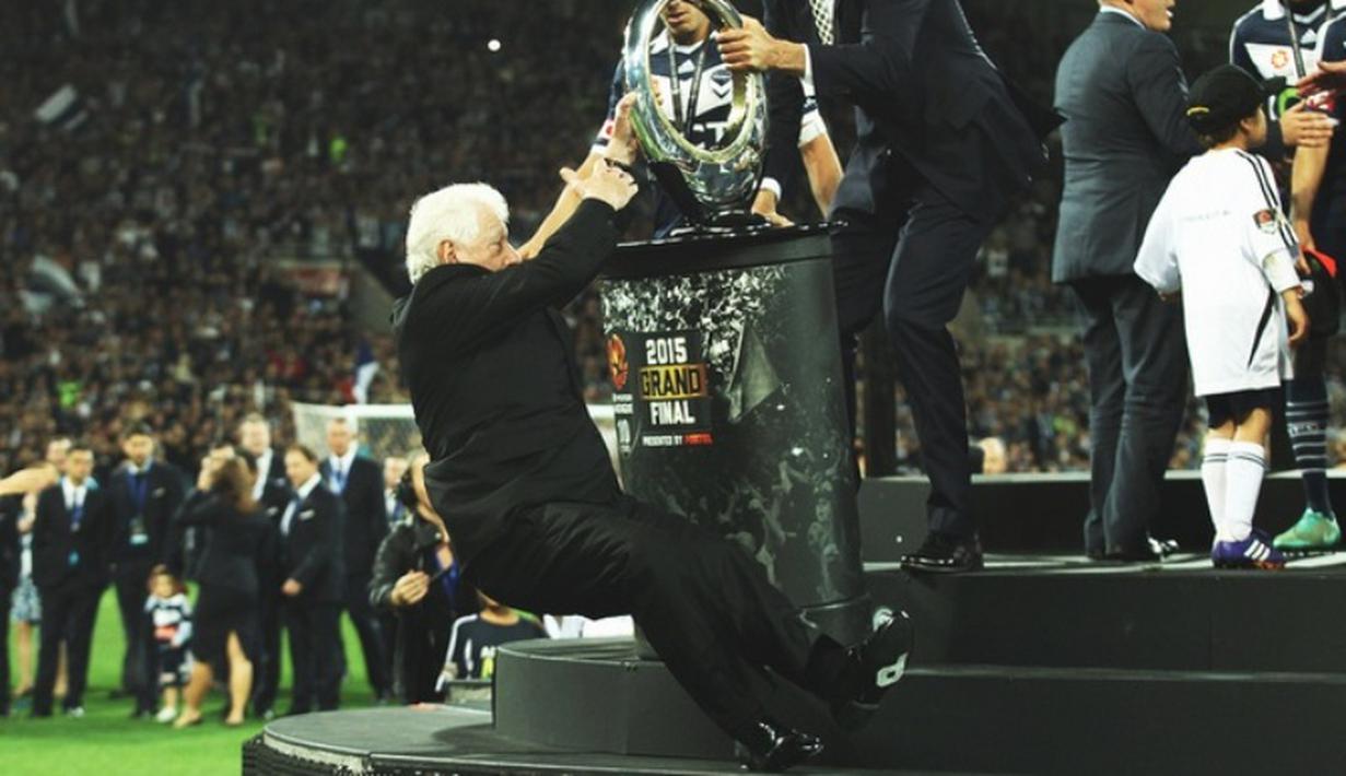 Presiden Asosiasi Sepak Bola Australia (FFA), Frank Lowy, terpeleset dan jatuh dengan kepala menyentuh tanah terlebih dulu saat hendak menyerahkan piala A-League Grand Final 2015 yang dimenangkan oleh Melbourne Victory, Minggu (17/5). (www.twitter.com)