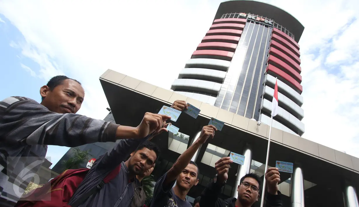 Aktivis Koalisi Masyarakat Sipil menunjukan Kartu Tanda Penduduk (KTP) Elektronik saat melakukan aksi di depan Gedung Komisi Pemberantasan Korupsi (KPK), Jakarta, Minggu (12/3). (Liputan6.com/Immanuel Antonius)