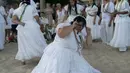 Seorang penganut kepercayaan Afro-Brasil menari memberi penghormatan kepada Yemenja sang Dewi Laut, ketika menyambut tahun baru di Pantai Copacabana di Rio de Janeiro (29/12/2019). Dalam kepercayaan Afro-Brasil, Yemanja diyakini sebagai representasi dewi laut yang cantik jelita. (AFP/Mauro Pimentel)