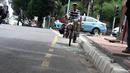 Pedagang menggunakan sepeda melewati jalur khusus sepeda yang disediakan di Jalan Imam Bonjol, Jakarta. Foto diambil pada Kamis (4/12/2014). (Liputan6.com/Faizal Fanani)