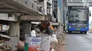 Bus Transjakarta melintas saat pekerja mengerjakan proyek perluasan Halte Bus Transjakarta Gelora Bung Karno (GBK) di Jalan Jenderal Sudirman, Jakarta, Selasa (24/7). (Liputan6.com/Faizal Fanani)