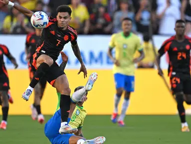 Penyerang Kolombia, Luis Diaz (atas) berebut bola dengan gelandang Brasil Bruno Guimaraes saat pertandingan grup D Copa America 2024 di Stadion Levi's, Santa Clara, California pada 2 Juli 2024 atau Rabu 3 Juli 2024 WIB. (Patrick T. Fallon/AFP)